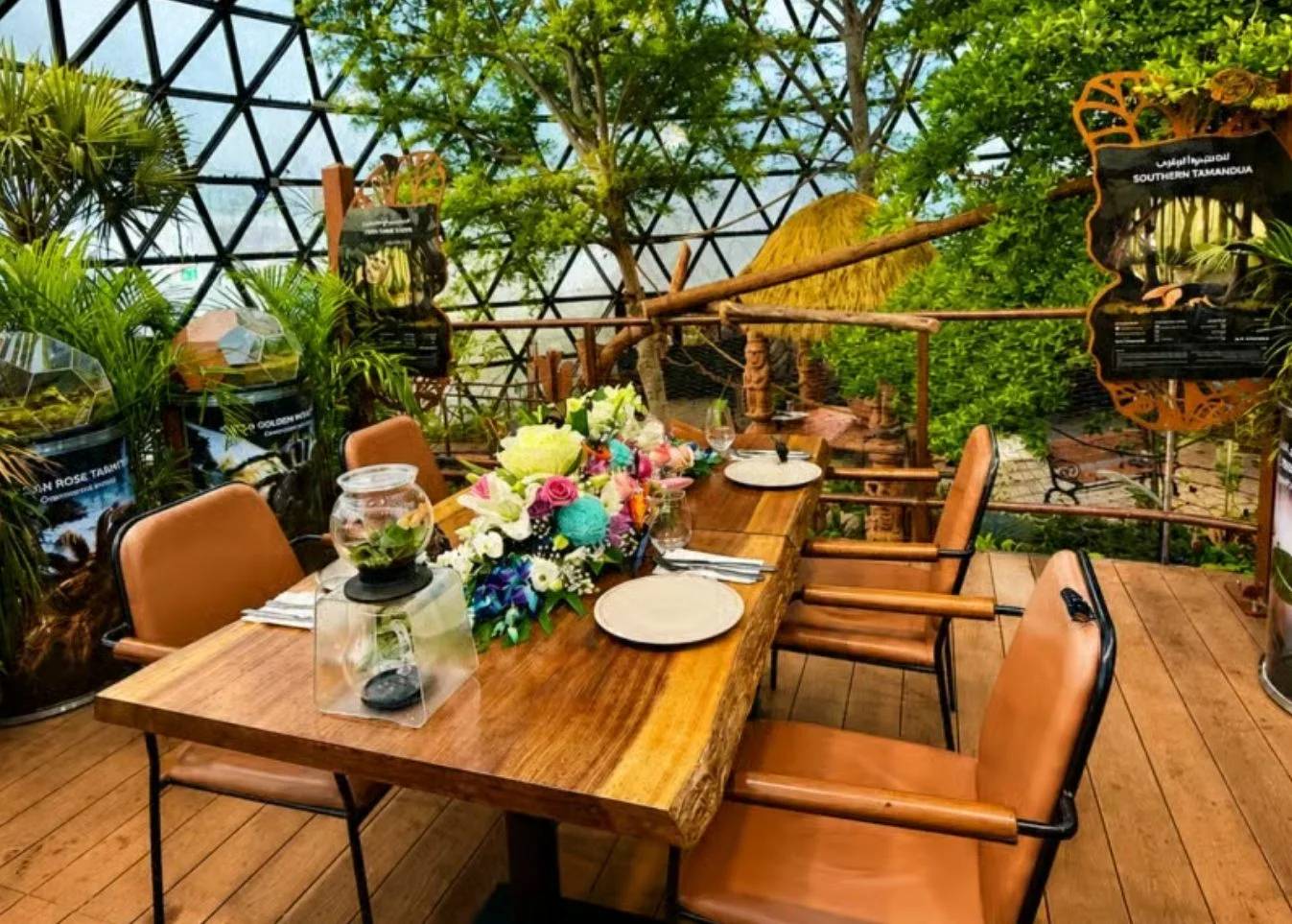 Elegant dining setup amidst lush greenery at The Butterfly Gardens Abu Dhabi, UAE.