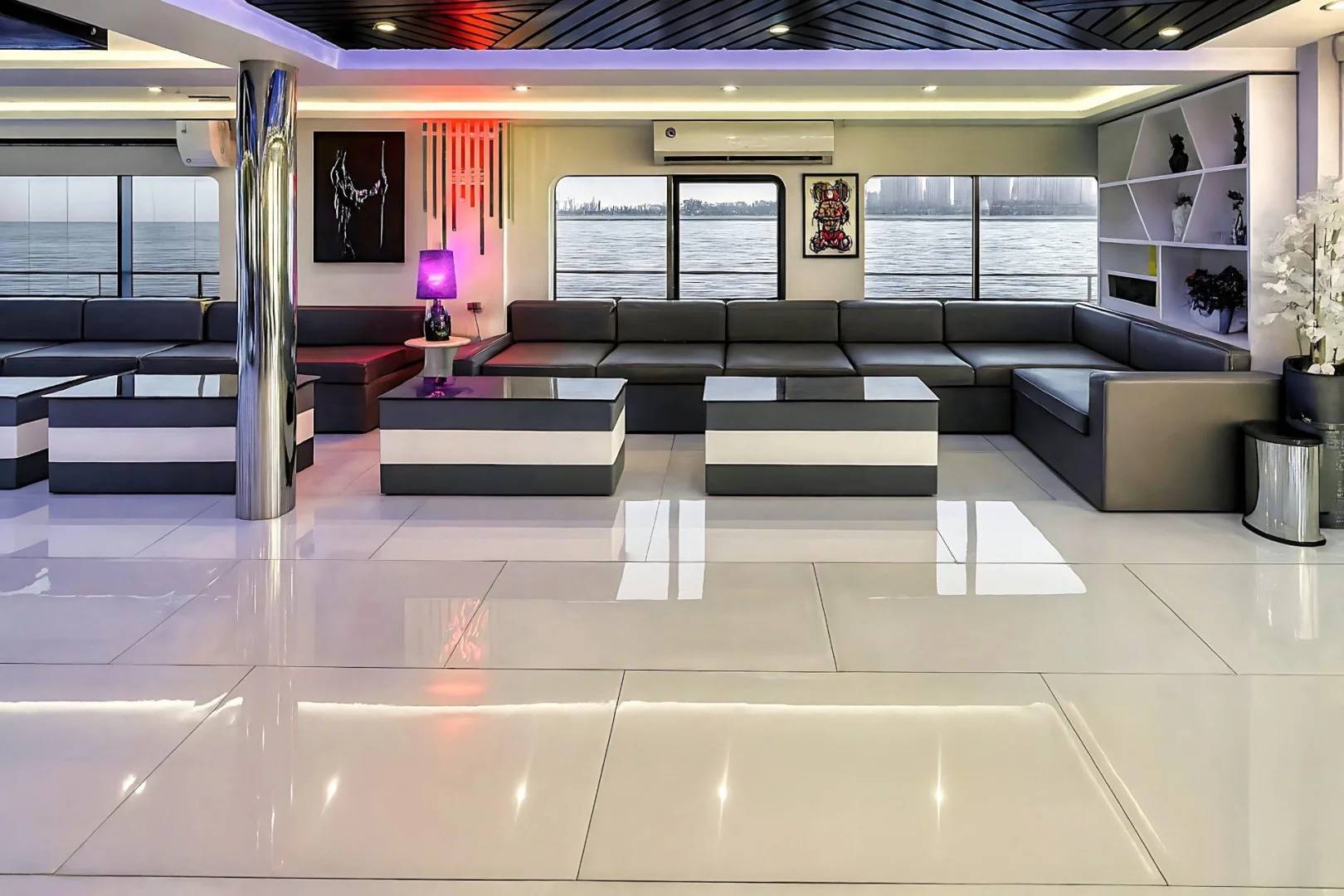 Modern lounge area with sofas and tables at Royal Rave Yacht, Dubai, UAE.