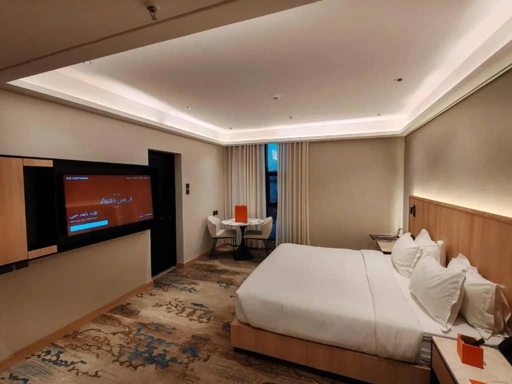 Modern guest room with bed and TV at Ayas Hotel Hail, Saudi Arabia.