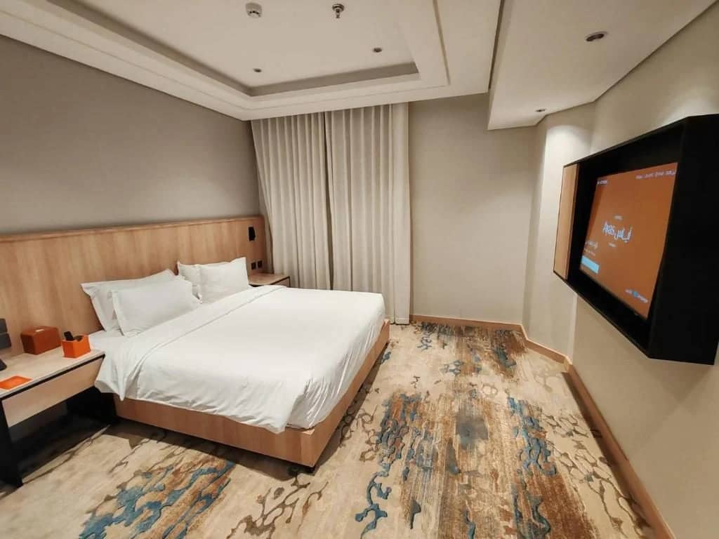 Modern guest room with bed and TV at Ayas Hotel Hail, Saudi Arabia