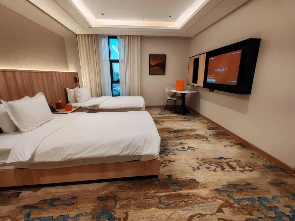 Guest room with twin beds and TV at Ayas Hotel Hail, Saudi Arabia.