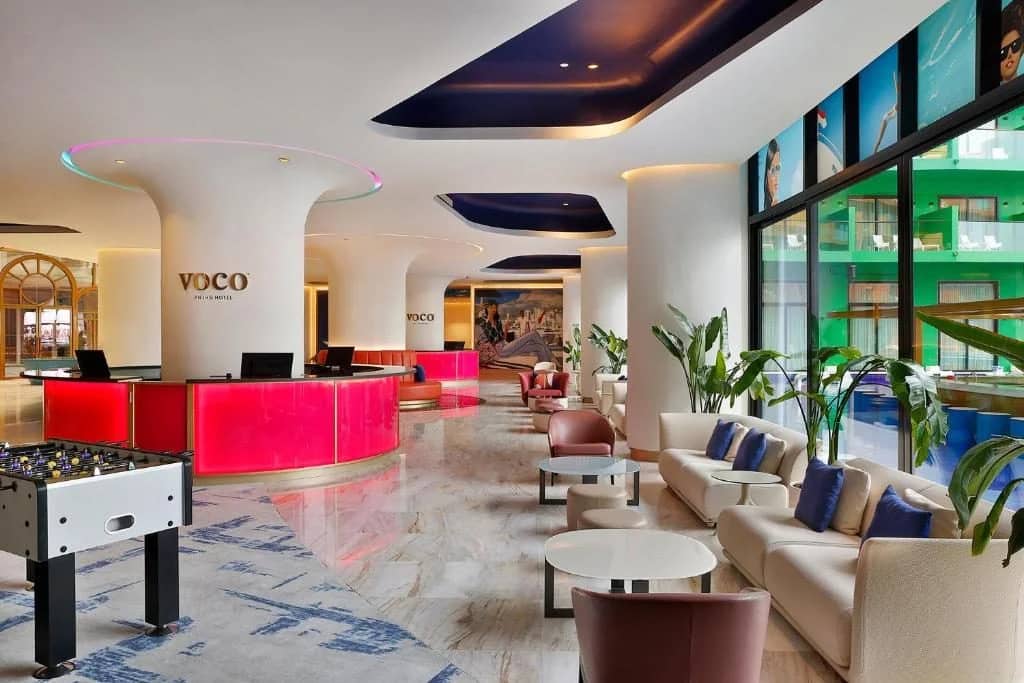 Modern lobby with seating and plants at Voco Dubai Nice The Heart of Europe.