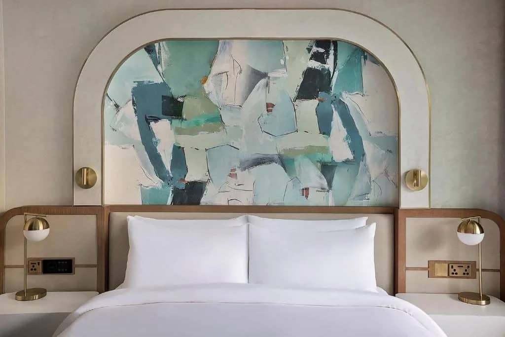 Elegant guest room with abstract headboard at Voco Dubai Nice, Dubai, UAE.