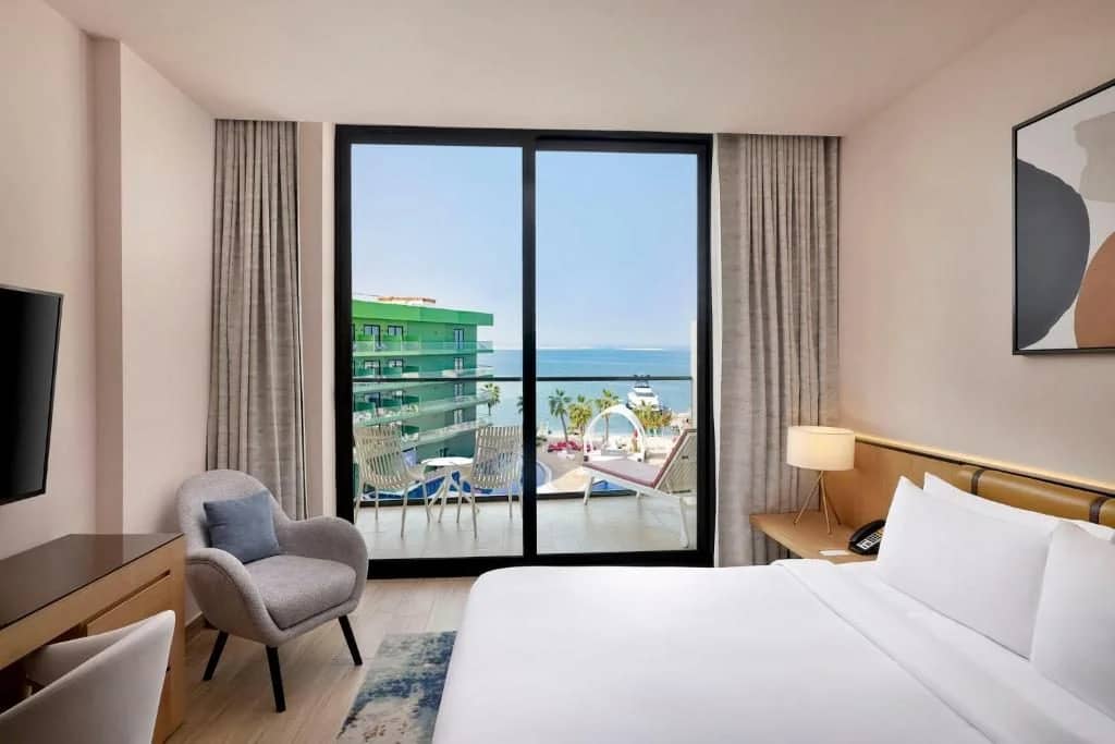 Guest room with balcony view at Voco Dubai Nice The Heart of Europe, Dubai.