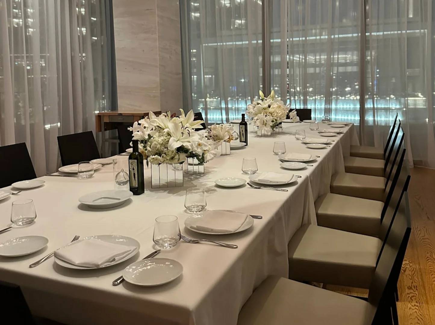 Elegant dining setup with floral centerpieces at Estiatorio Milos Dubai, UAE.