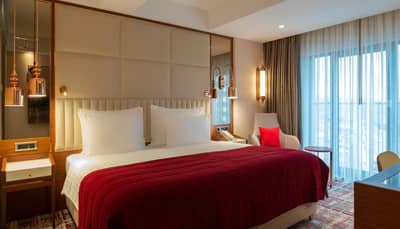 Mövenpick Hotel Istanbul Asia Airport - a hotel room with a bed with a red blanket at Mövenpick Hotel Istanbul Asia Airport in Istanbul