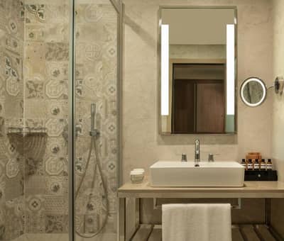 Mövenpick Hotel Istanbul Asia Airport - a bathroom with a sink and a shower with a mirror at Mövenpick Hotel Istanbul Asia Airport in Istanbul