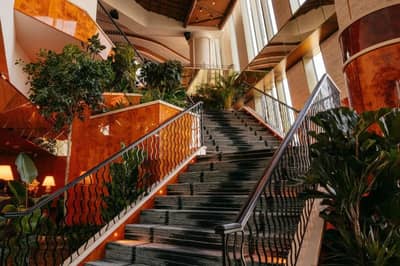 Elegant staircase with plants, Lion in the Sun Dubai interior.