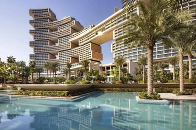 Atlantis The Royal Dubai with pool and palm trees.