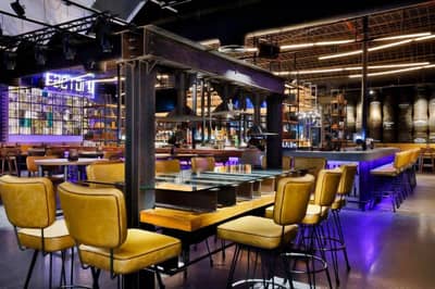Modern restaurant interior at Hilton Dubai Palm Jumeirah, vibrant lighting.