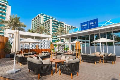 Outdoor seating at Hilton Dubai Palm Jumeirah with umbrellas and sofas.