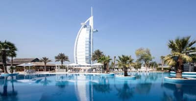 Jumeirah Beach Hotel pool with Burj Al Arab in background, Dubai.