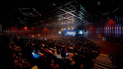 Crowded event at Dubai World Trade Centre auditorium, dimly lit atmosphere.
