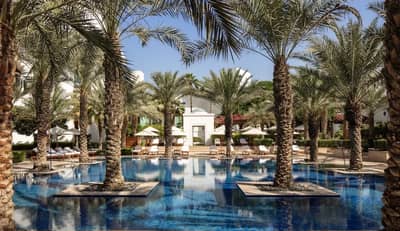 Palm trees surrounding pool at Dubai Creek Golf & Yacht Club.
