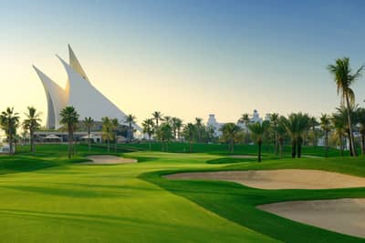 Dubai Creek Golf & Yacht Club lush green course, palm trees.