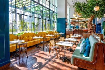 Couqley French Brasserie Downtown Dubai, elegant dining area with greenery.