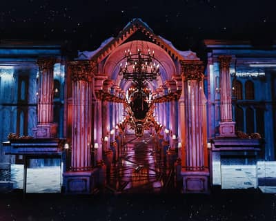 Lavish interior of DREAM Dubai Dinner Show venue, featuring ornate columns.