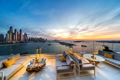 Sunset view from The Penthouse Dubai rooftop lounge, overlooking city skyline.