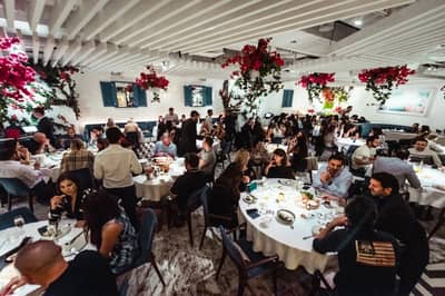 Crowded dining area at Opa Dubai with vibrant decor.