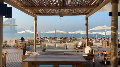Beachfront seating at Surf Club Dubai with ocean view.