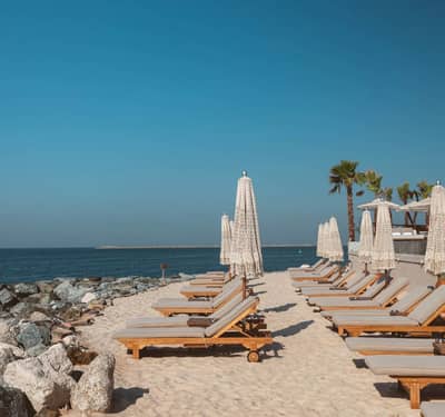 Sun loungers and umbrellas at Be Beach DXB, Dubai beachfront.