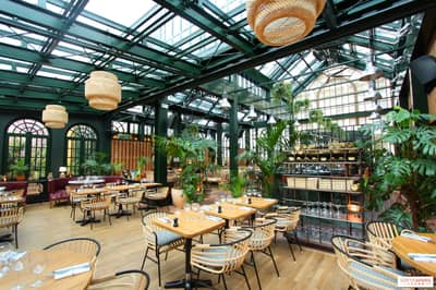 Eugène Eugène Restaurant Dubai with lush greenery and elegant seating.