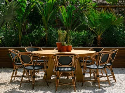 Outdoor seating at Eugène Eugène Restaurant, Dubai with lush greenery.
