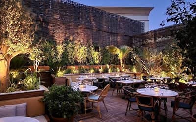 Eugène Eugène Restaurant Dubai outdoor dining area with lush greenery.