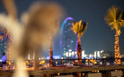 Elegant beachfront dining at Be Beach DXB, Dubai, with city skyline.