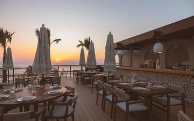 Be Beach DXB restaurant terrace at sunset, Dubai coastline view.