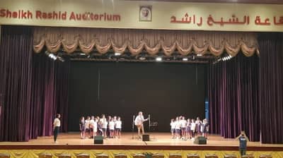 Children performing on stage at Sheikh Rashid Auditorium, Dubai.