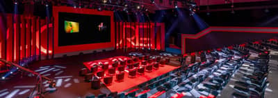 Expo Centre Sharjah auditorium with red lighting and seating arrangement.