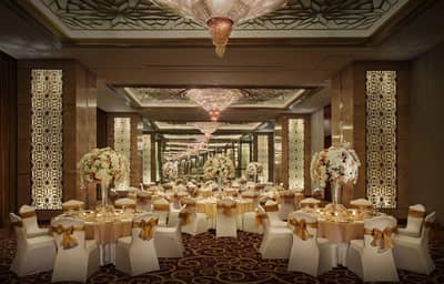 Elegant ballroom at The Meydan Hotel, Dubai, with floral centerpieces.