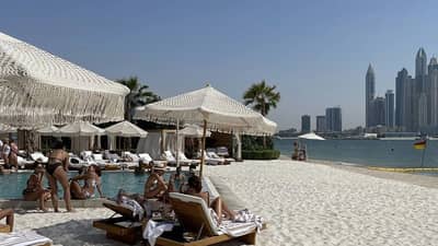 Kyma Beach Dubai with loungers, umbrellas, and city skyline view.