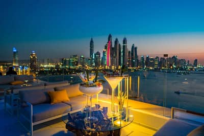 Evening cityscape from The Penthouse Dubai with cocktails on table.