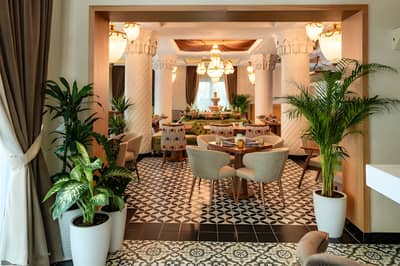 Elegant dining area at Grand Zor Restaurant, Dubai with lush plants.