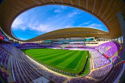Hazza Bin Zayed Stadium, Al Ain, vibrant green field, empty seats.