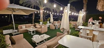 Outdoor seating at Peaches & Cream Beach Restaurant, Dubai, with string lights.