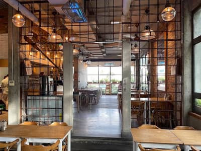 Interior of Mamaesh Al Manara restaurant, Dubai, with wooden tables.