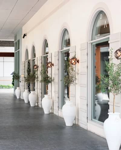 Gaia Dubai exterior with arched windows and white planters.