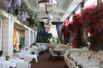 Elegant dining area with floral decor at Gaia Dubai restaurant.