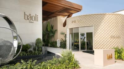 Baoli Restaurant Dubai entrance with modern design and greenery.