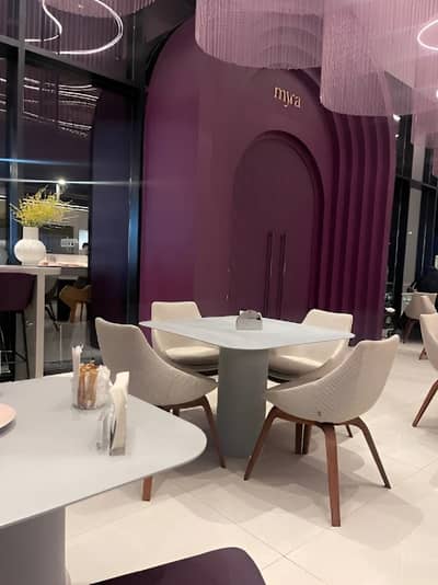 Modern interior of Myra Cafe Jeddah with purple accents and seating.