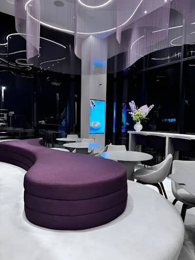 Modern interior of Myra Cafe Jeddah with purple seating.