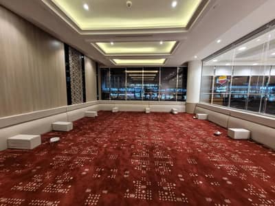 Spacious dining area with red carpet at Al Romansiah Restaurant Makkah.