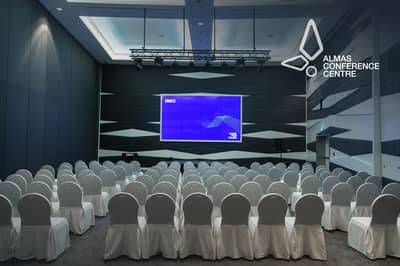 Almas Conference Centre auditorium with rows of white chairs, Dubai.
