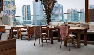 Cozy outdoor seating at The House Restaurant Lusail with city view.