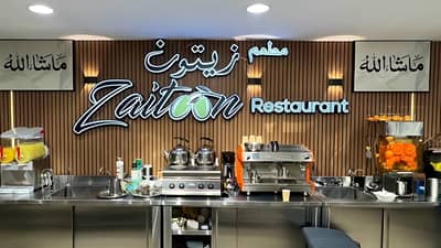Zaitoon Restaurant Madinah interior with coffee machines and juice dispensers.
