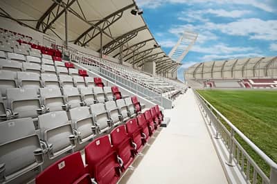 Abdullah Bin Khalifa Stadium seating, Doha, with clear sky.