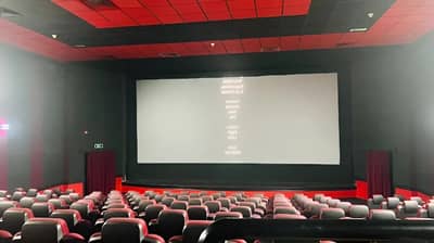Empty theater at Gulf Cinema Ras Al Khaimah, red seats, large screen.